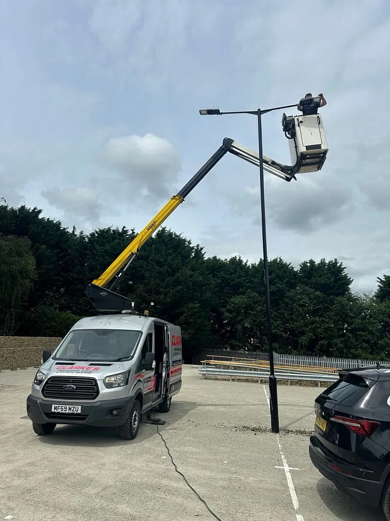 Cherry picker cleaning lighting in a car park