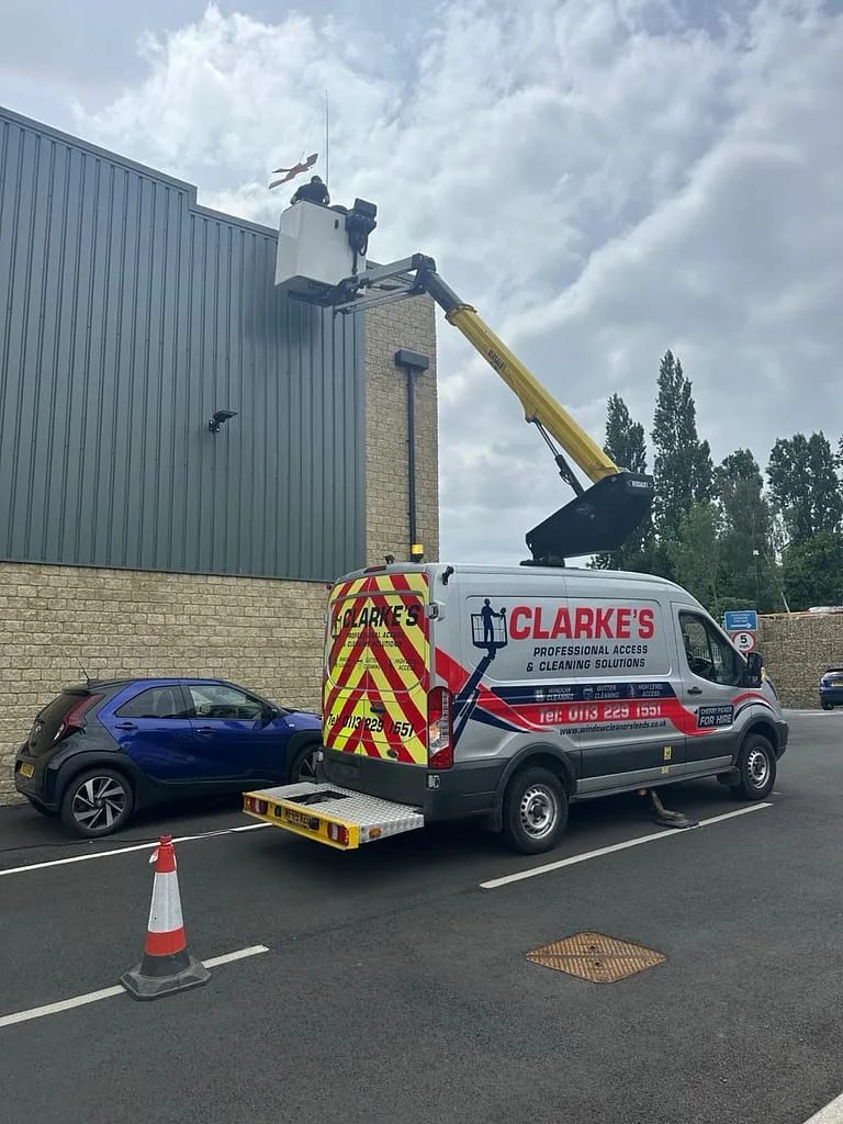 Cherry picker cleaning high-level windows on offices